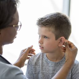Child With Hearing Aid Receiving Hearing Checkup From Audiologist